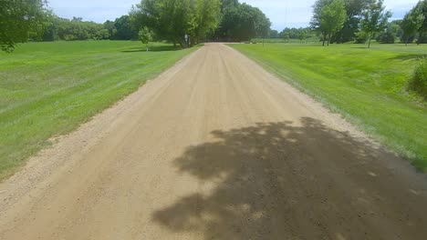 pov thru rear window while driving thru a county park in rural south dakota on a gravel road