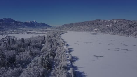 4k aerial video view of alpine snowy valley forest road and frozen river in peak of winter overflight - drone collection stock video