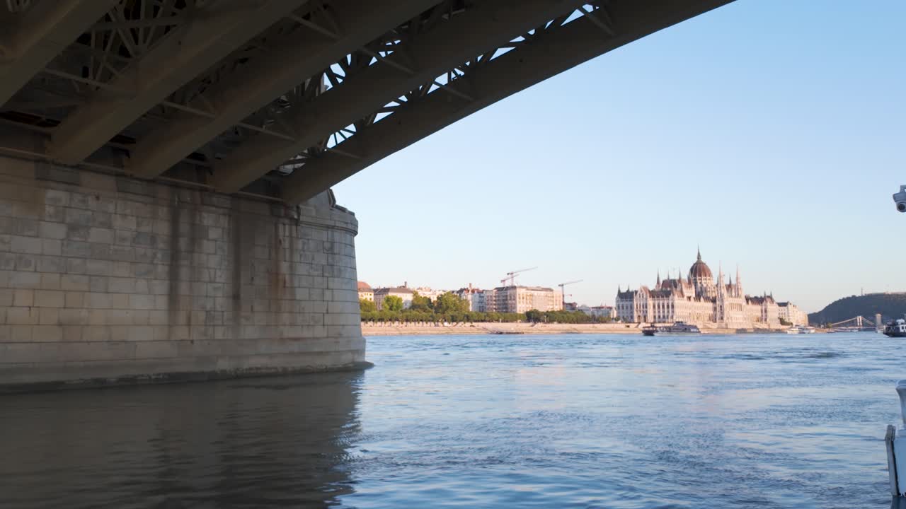 Boat gliding on the Danube with Hungarian Parliament Building in Budapest at sunset