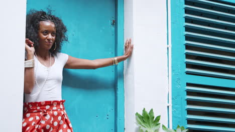 Moda-Joven-Mujer-Negra-Vistiendo-Pantalones-De-Lunares-Rojos-Apoyado-En-Una-Puerta