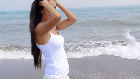 Mujer-Caminando-Por-La-Playa-Y-Sonriendo-A-La-Cámara