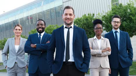 grupo de empresarios multiétnicos con ropa elegante sonriendo y mirando la cámara en la calle
