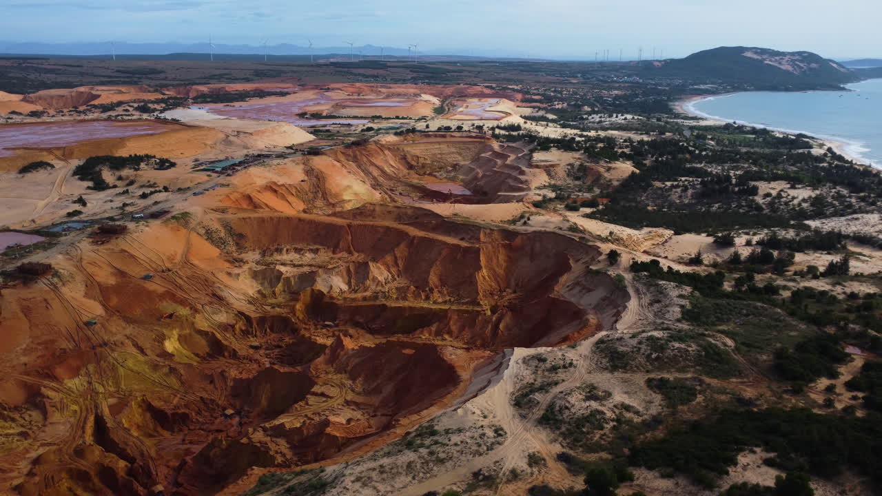vista panorámica aérea de grandes agujeros en las dunas de arena y detrás de un mar encantador