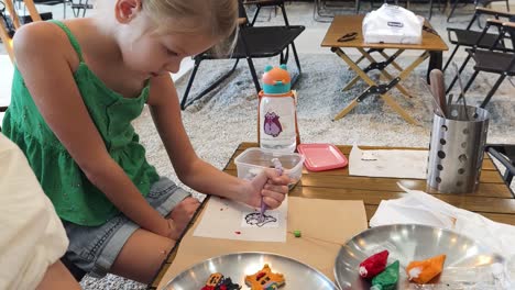 child painting at a cafe