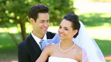 Happy-newlyweds-embracing-each-other-in-the-park