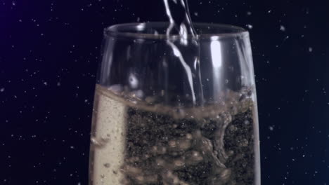 animation of white specks floating over glass of champagne on black background