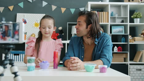 father and daughter making slime together
