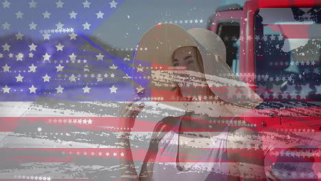 Animation-of-flag-of-usa-over-caucasian-woman-by-car-on-beach