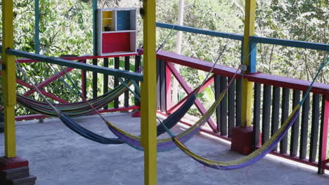 las hamacas coloridas se balancean suavemente en la brisa en el balcón del albergue del bosque