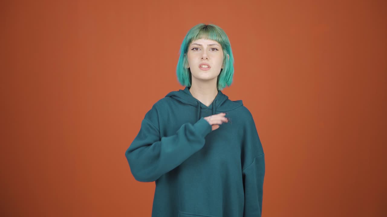 젊은 여성은 카메라를 쳐다보며 경고하고 있습니다.