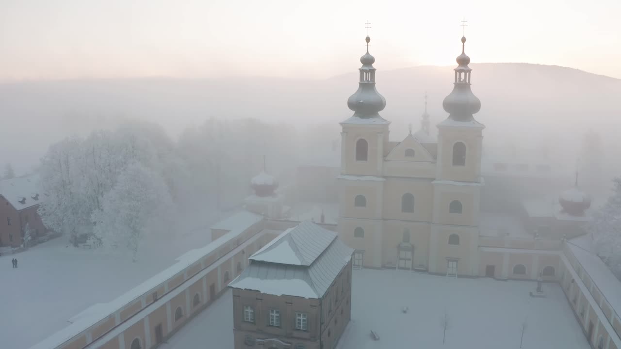 Christian monastery on top of the hill in fog in winter from drone