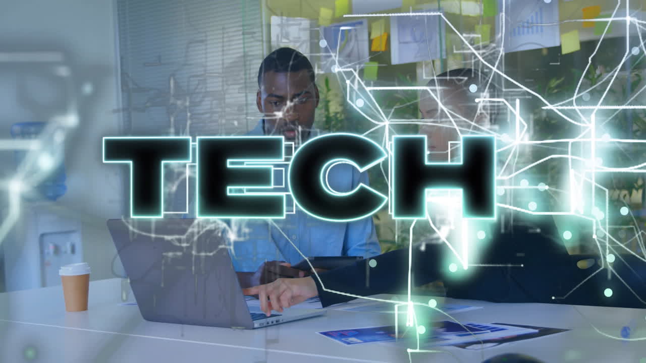 coworkers collaborating at desk in office, displaying glowing TECH overlay with laptops and charts