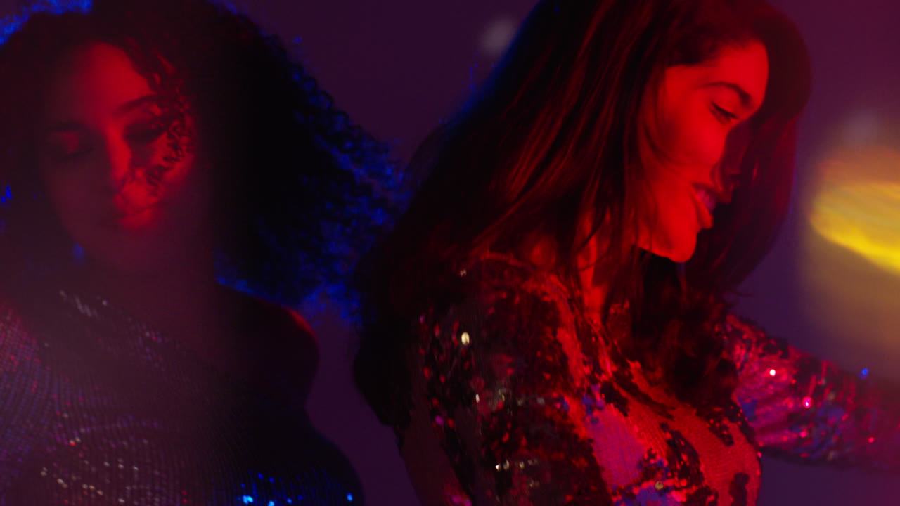cerca de dos mujeres en un bar de club nocturno o discoteca bailando con luces brillantes 12
