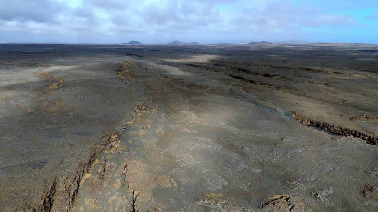 aerial view of The Bridge between Continents footbridge spanning a rift between the Eurasian and North American tectonic plates cloud shade on the arid ground