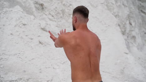 muscular shirtless man showing his body on the natural background of mountains. strong bearded man in the open air.