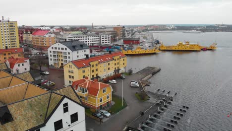 aerial footage over karlskrona, sweden focusing three yellow ferries and old houses