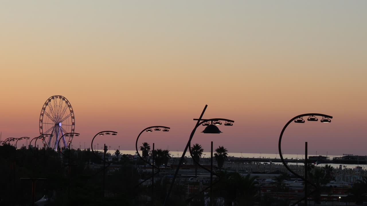 Colorful sunset at tropical beach with Ferris wheel, summer evening establisher