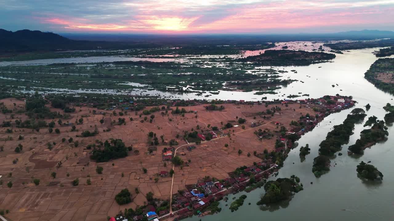 Aerial tracking left of Don Det island in Laos, with lush vegetation and the Mekong River, blue hour dusk glow