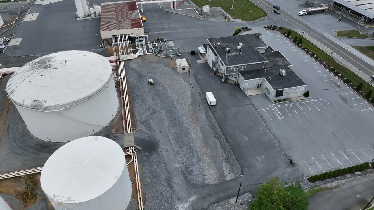 Several fuel tanks on industrial area of company in America. Aerial top down shot. Truck loading petroleum on ramp. Street in suburb of Harrisburg, Pennsylvania