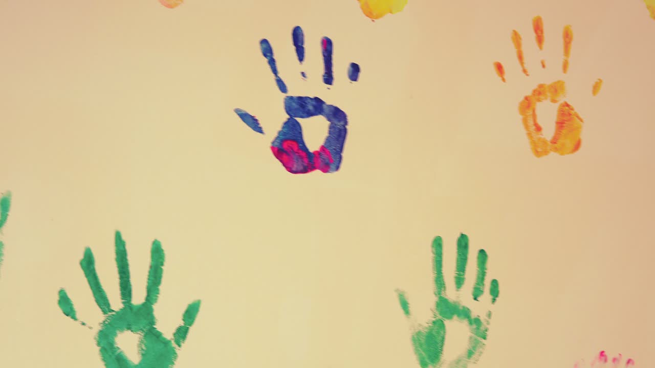 Closeup view of colorful child's handprints painted on the wall. 4k shot