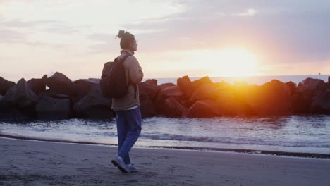woman walking on a beach at sunrise