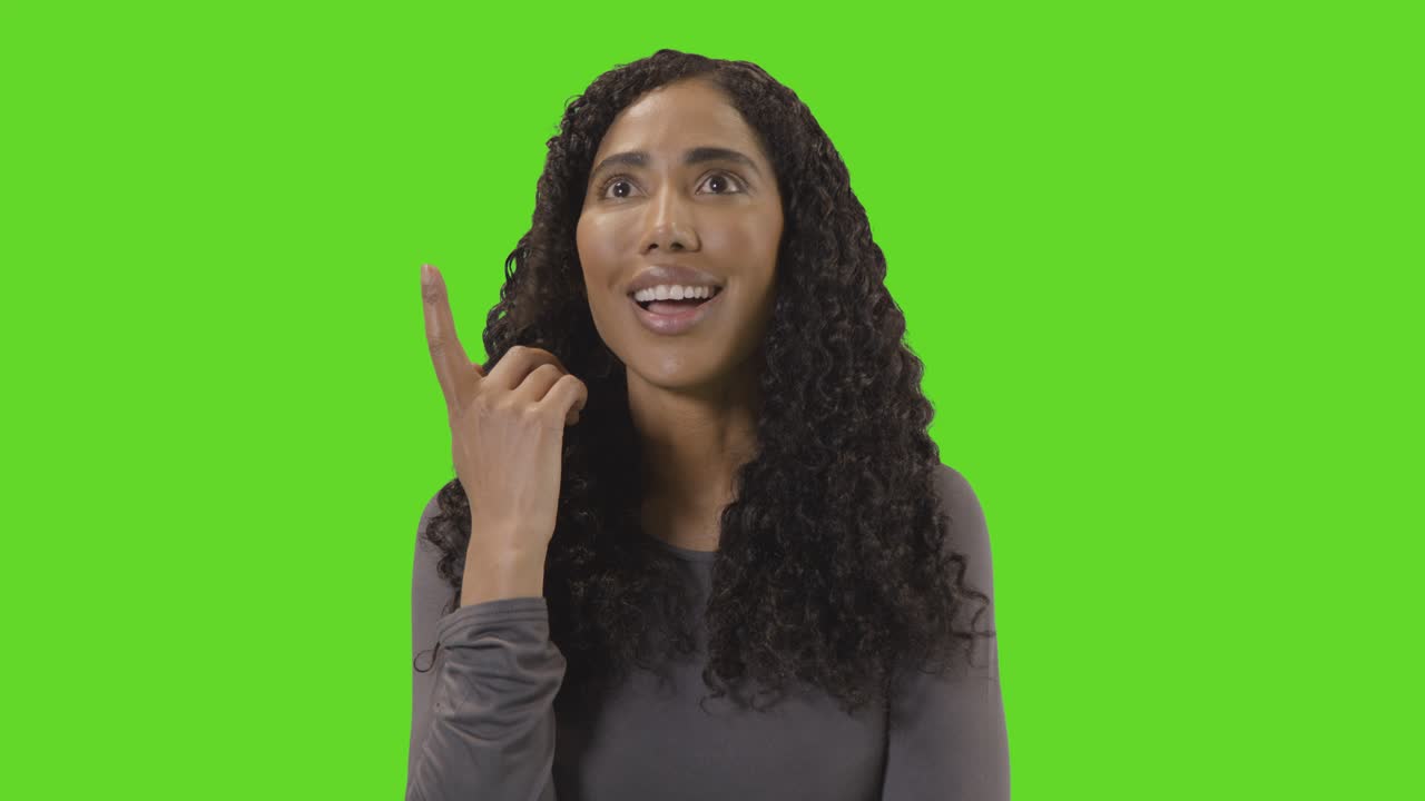 Portrait Of Woman Being Inspired By Good Idea Against Green Screen At Camera 1