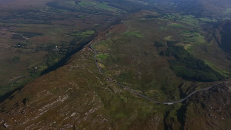 caha pass, county cork, ireland, september 2024. drone stunning overview from high angle perspective of winding mountain road crossing the border with county kerry.