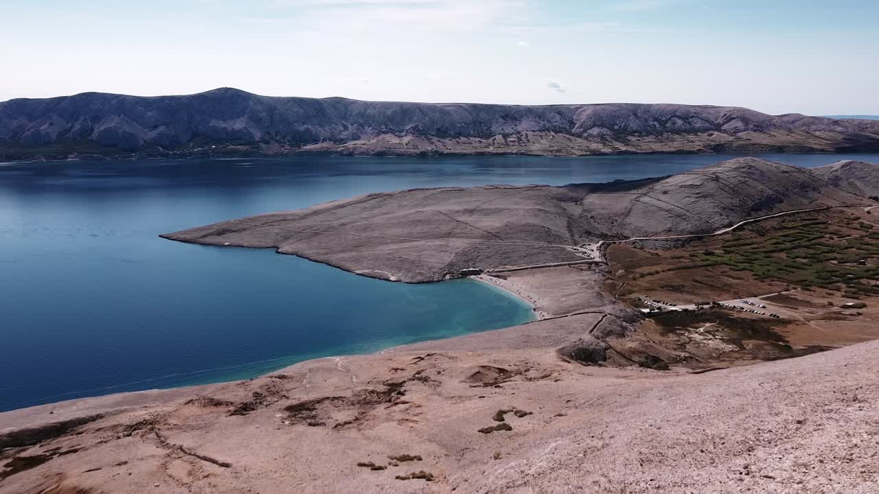 무인 항공기는 바위 산을 통해 비행하여 해안과 바다를 드러냅니다.