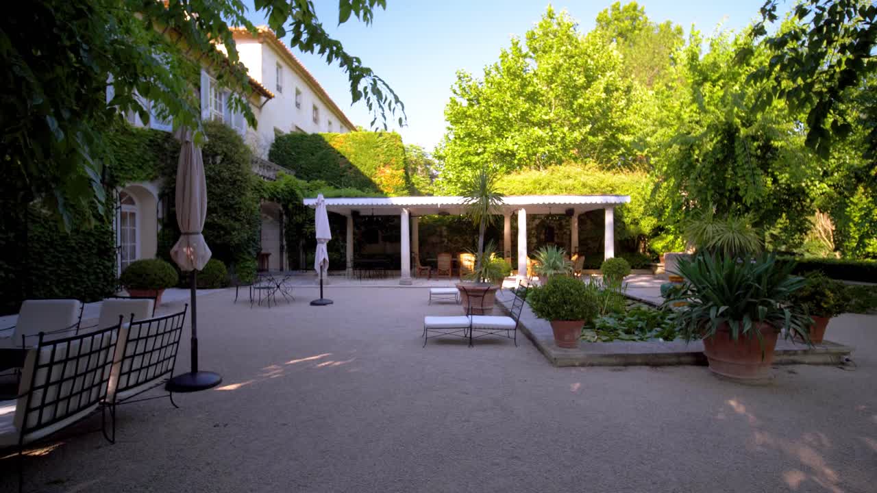 Carrellata di un giardino ben curato con posti a sedere esterni recintati in una villa