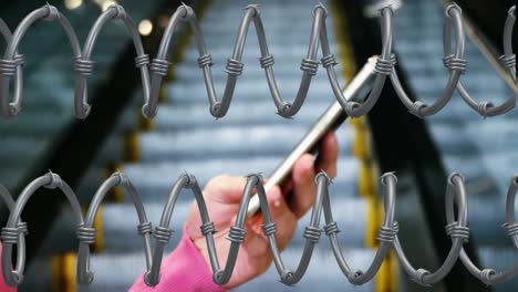 barbed wires against hands using smartphone