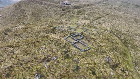 aerial view of ancient stone ruins in a grassy highland