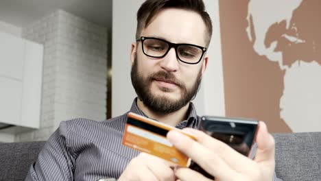 man using online banking with smart phone and card