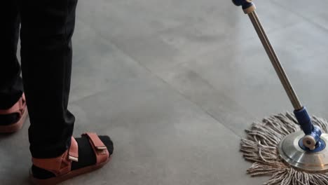 person methodically cleaning a shiny floor