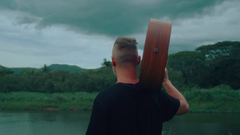 man with guitar by the river
