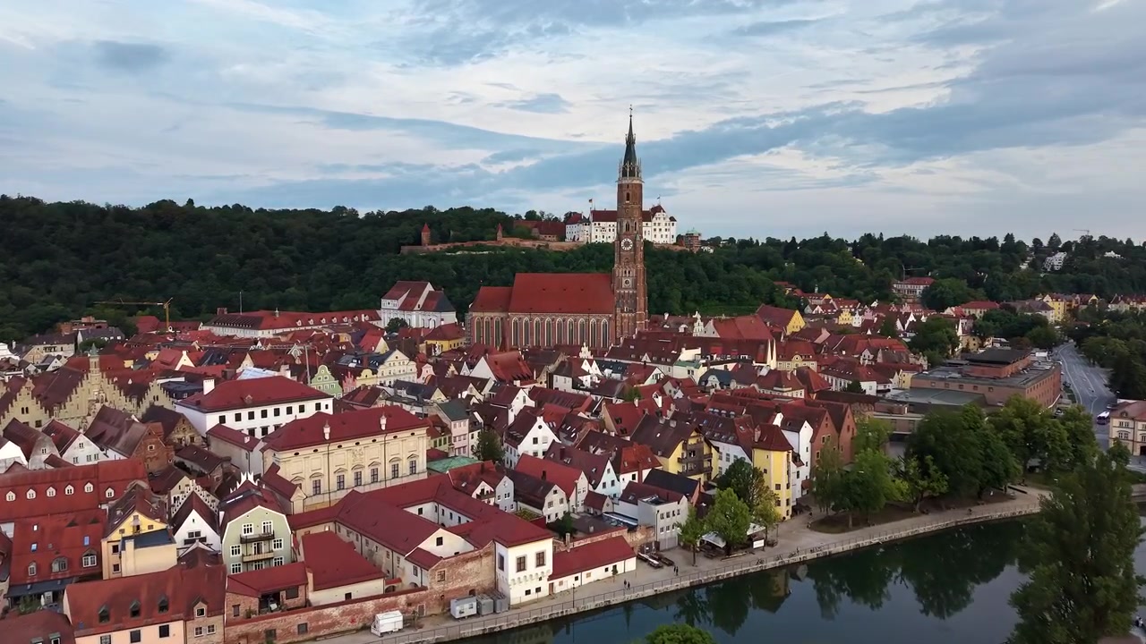 Veduta aerea con drone della Chiesa di San Martino con la sua alta torre in mattoni, del Castello di Trausnitz sulla collina e del fiume Isar, Landshut, Germania