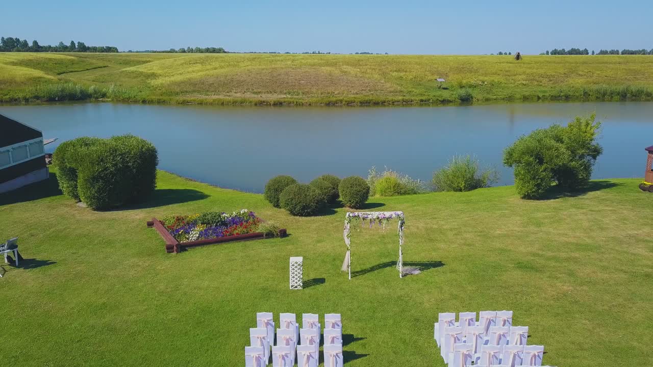 luogo di matrimonio con arco e sedie vicino al fiume vista superiore