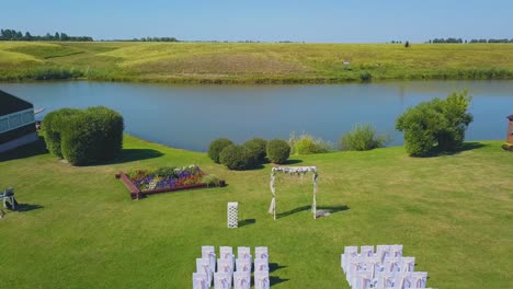 wedding venue with arch and chairs near river upper view