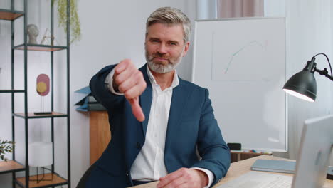 businessman giving thumbs down in an office meeting