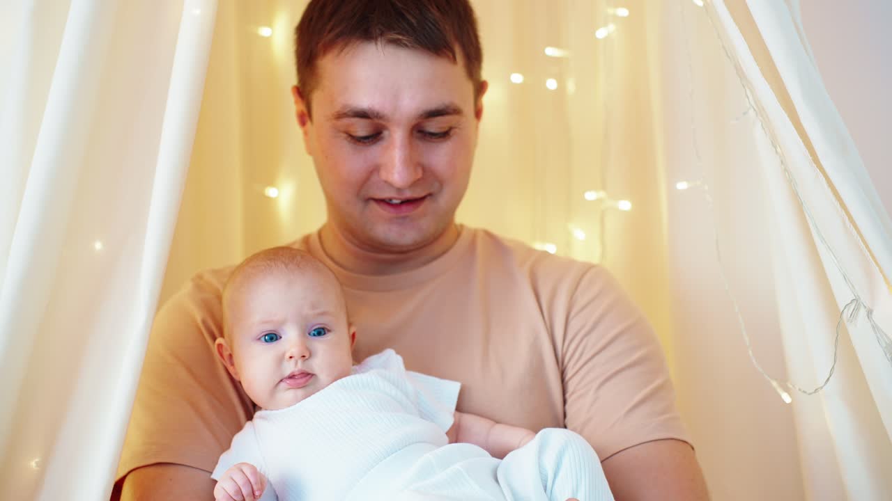 Peri Işıklarıyla Süslenmiş Rahat Bir Ortamda Bebeğini Tutan Sevgi Dolu Baba