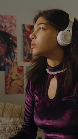 young woman listening to music in her bedroom