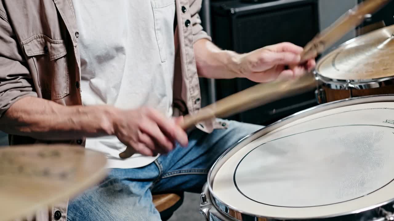 Close-up video of a drummer's hands playing a snare drum, captured from a side angle