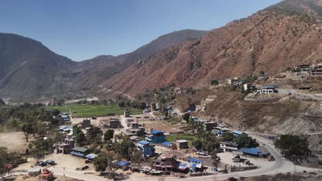 Spectacular-Aerial-View-of-Scenic-Mountain-Settlement:-Majestic-Peaks,-Tranquil-Rivers,-and-Human-Habitation-Amidst-Nature