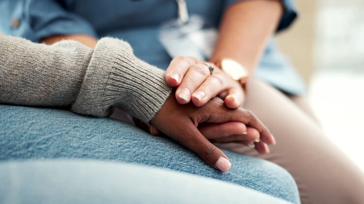 Infermiera, mani che si tengono ed empatia per il paziente