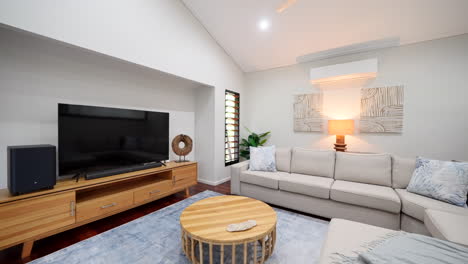 establishing shot of grey sectional couch and wooden brown furniture and recessed entertainment center