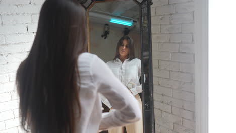 woman trying on clothes in front of a mirror