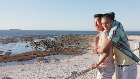 happy diverse gay male couple embracing at promenade by the sea, slow motion