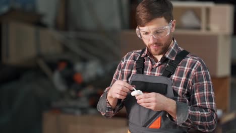 Un-Hombre-Agradable-Con-Uniforme-De-Trabajo-Usa-Auriculares-Portátiles