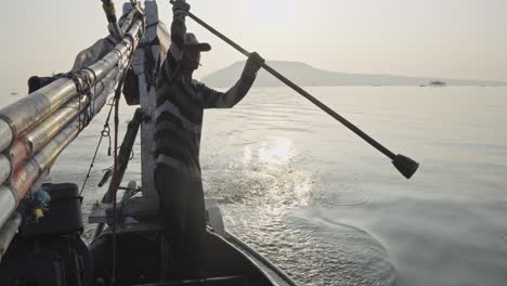 a traditional fisherman demonstrates his unique technique of steering his boat with his feet while deftly rowing through the sea