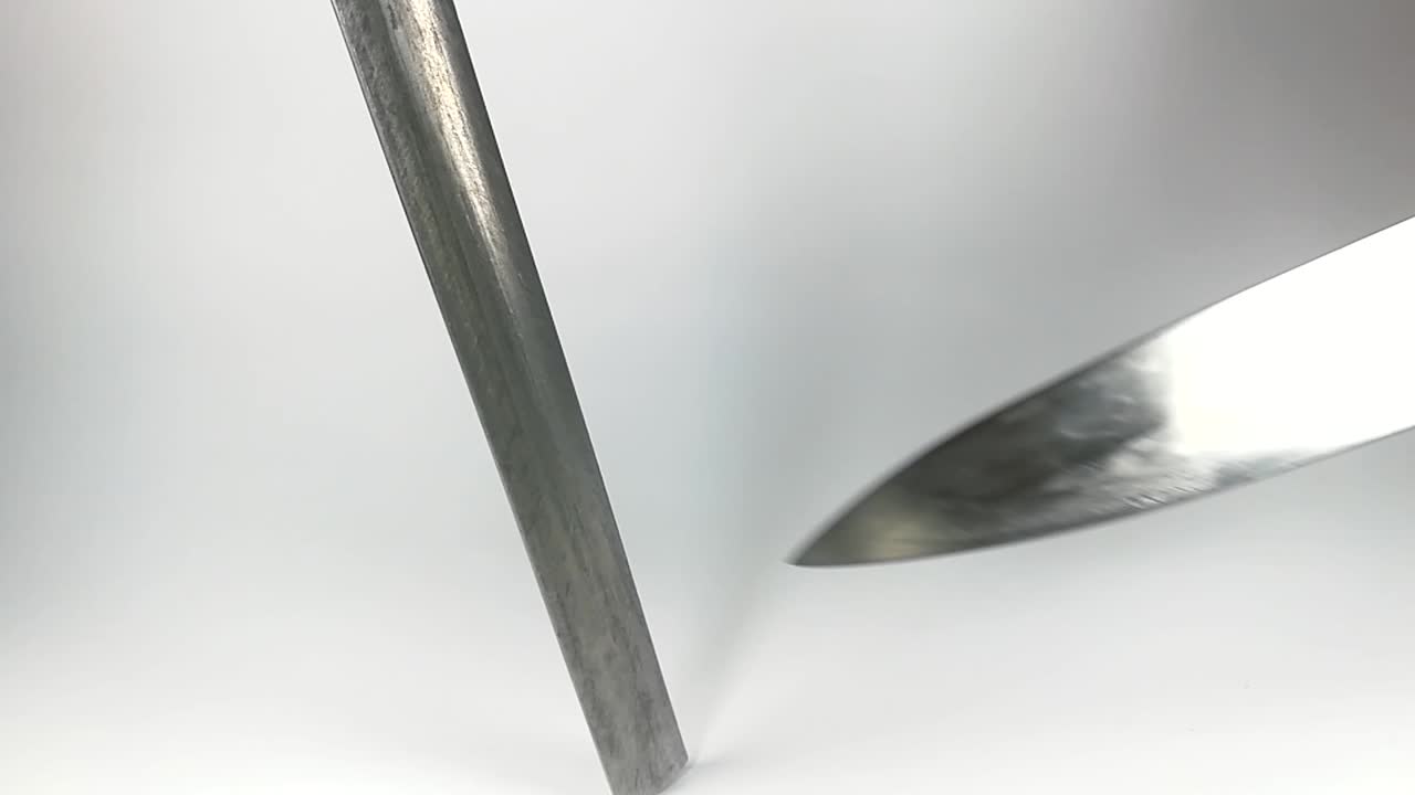 aislado, mano masculina afilando cuchillo japonés de acero inoxidable, slomo