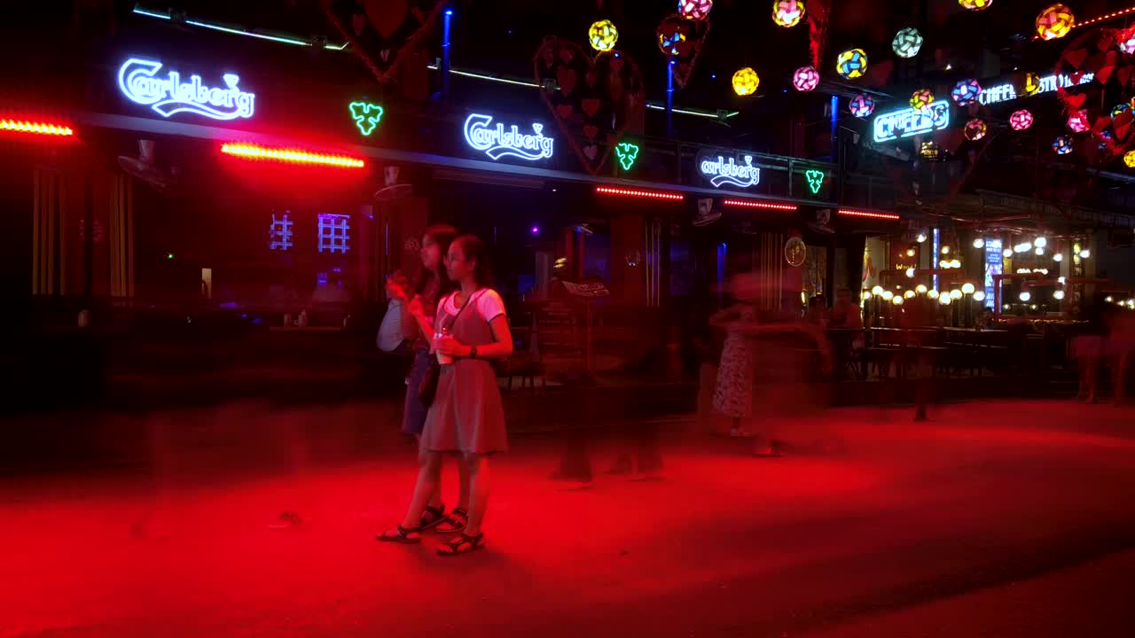 Nightlife in Siem Reap Cambodia on Pub Street with neon lights. Timelapse on slider.